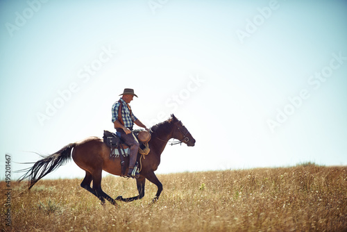 Galloping with freedom. Action shot of a man riding a horse in a field.