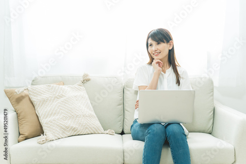 ソファに座る中高年女性（パソコン） 