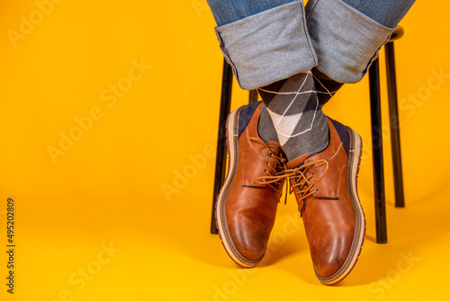 Beautiful shoes on the feet. Yellow background.