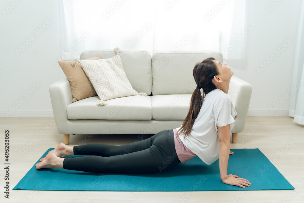 部屋でヨガをする中高年女性(コブラのポーズ)
部屋でヨガをする中高年女性(コブラのポーズ)
