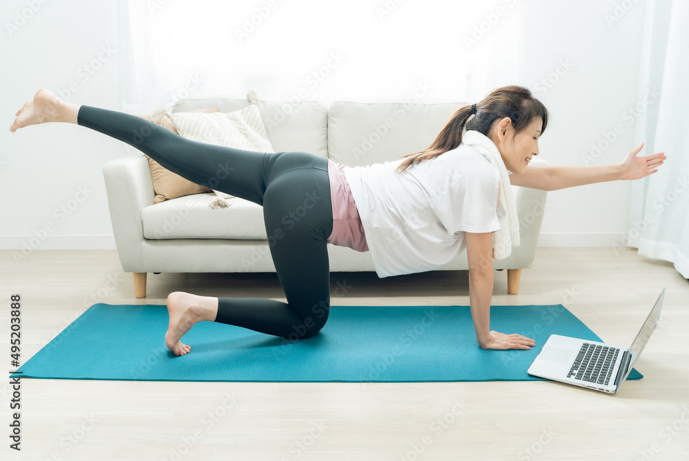 Fototapeta premium オンラインヨガをする中高年女性（猫のバランスポーズ） 