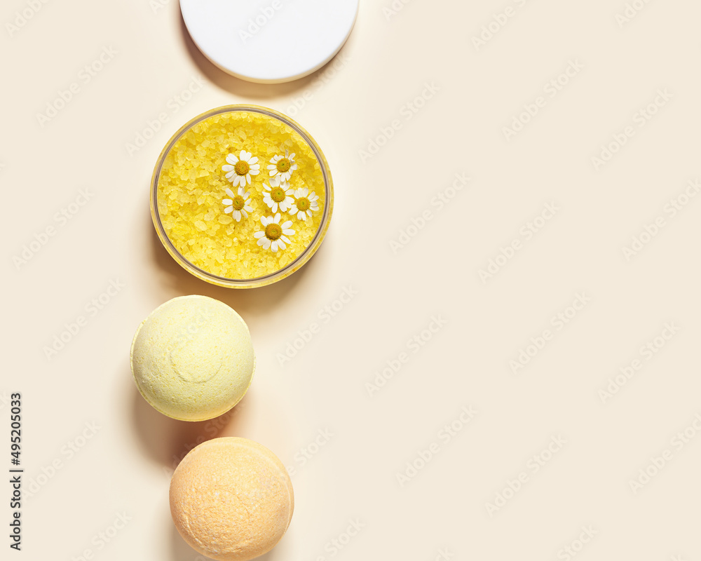 Top view bath bombs and sea salt with herbal extract of chamomile, spa products close up. Natural cosmetic for beauty treatment and body care, home care, herbal medicine, beige background Top view bath bombs and sea salt with herbal extract of chamomile, spa products close up. Natural cosmetic for beauty treatment and body care, home care, herbal medicine, beige background