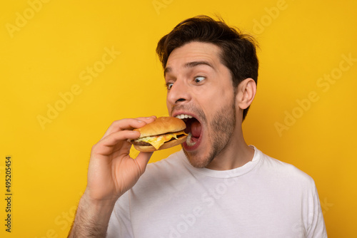 Funny Guy Holding Burger Biting Sandwich At Studio