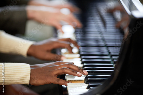 Close-up of woman playing the piano together with man in duet during their performance