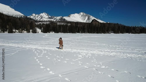 Girl walking through the iced lake. Drone footage.