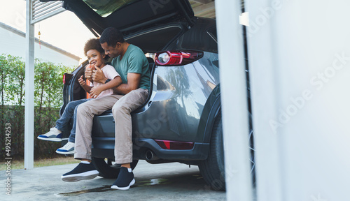 фотографія African American Father and son sitting in car trunk, Happy family on road trip