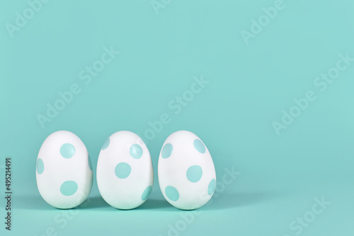 Photography Three easter eggs with dots on mint green background