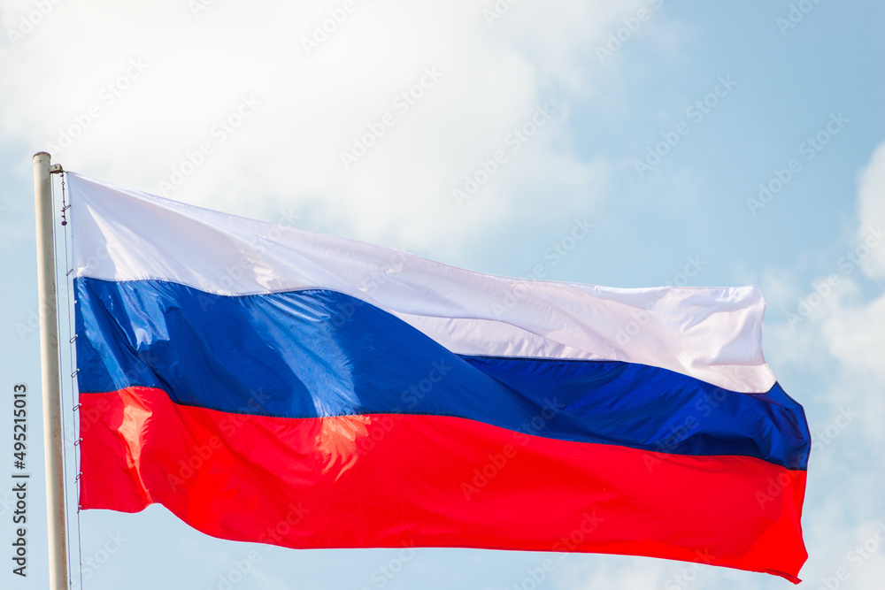 Russia flag is waving in front of blue sky