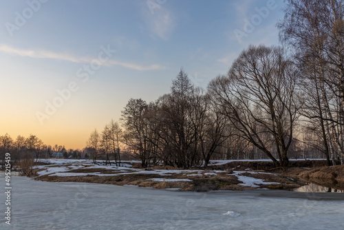Melting ice and snow. Spring landscape  evening forest with a river. The beginning of spring. Awakening of nature. Charming landscapes of spring nature.