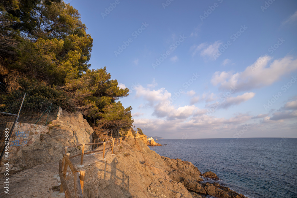 Evening seascape with coastline illuminated by sunlight. View of the sea and part of the land.