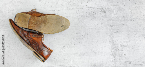 Obraz na plátne Top down view, worn classic dark brown brogue shoes on white board