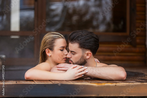 portrait of a couple kissing in a tub of water
