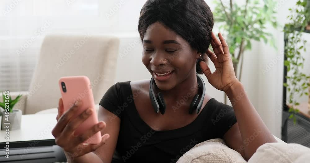 Happy woman video chatting using mobile phone at home Happy woman video chatting using mobile phone at home