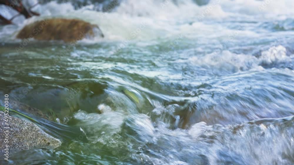 River flowing over rocks, close up detail, rapid green and white water ...