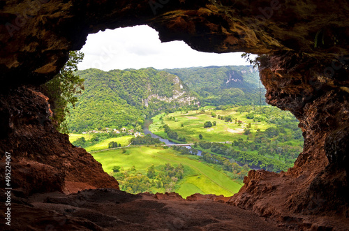  Window Cave (Cueva Ventana) in Arecibo near San Juan, Puerto Rico. View through lush green scenery through the cave opening shaped like a window that is at the end of hike. photo