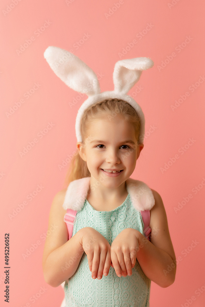 Beautiful cute little girl in Easter bunny ears smiling on a pink background. Easter postcard Beautiful cute little girl in Easter bunny ears smiling on a pink background. Easter postcard