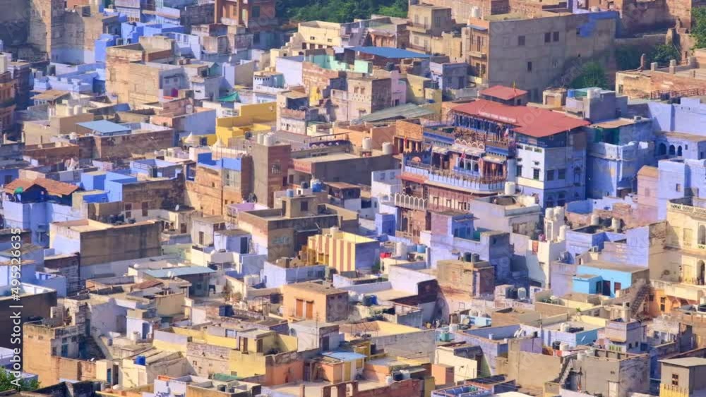 Jodhpur the Blue City aerial view. Blue painted houses and birds flying in the morning above brahmin houses, view from Mehrangarh Fort, Rajasthan, India. Camera zoom out Jodhpur the Blue City aerial view. Blue painted houses and birds flying in the morning above brahmin houses, view from Mehrangarh Fort, Rajasthan, India. Camera zoom out