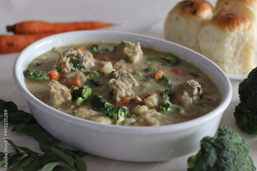 Stewed chicken with vegetables. Kerala style preparation with carrots, broccoli, potato, chicken, coconut milk and spices. Shot on white background Stewed chicken with vegetables. Kerala style preparation with carrots, broccoli, potato, chicken, coconut milk and spices. Shot on white background