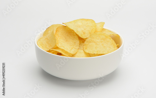 Patatas fritas o chips en un bol de cerámica blanca sobre fondo blanco