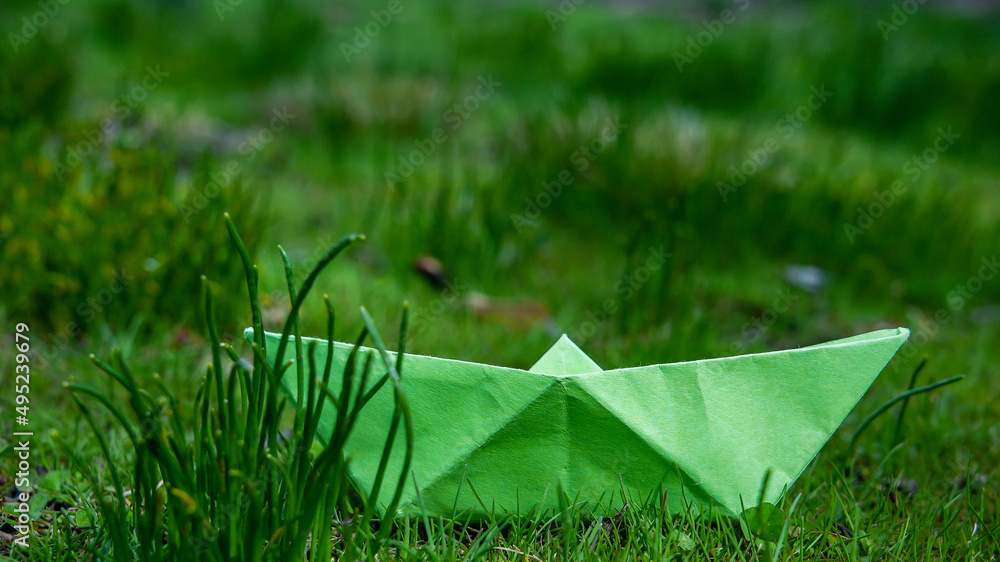 Green paper boat outdoor in grass
