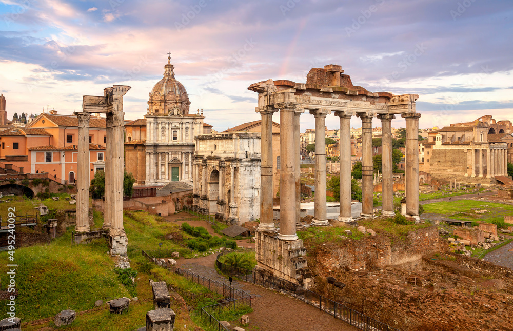 View of the temple of Saturn in Roman forum, Italy. Ruins of Septimius Severus Arch and Saturn Temple. Rainbow over the Roman forum. Rome architecture and landmark.