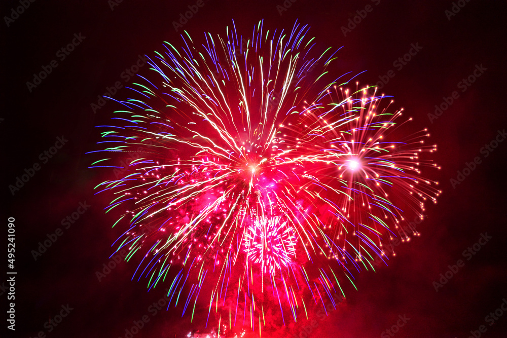 Red fireworks in the night sky at New Year's Eve celebration Red fireworks in the night sky at New Year's Eve celebration