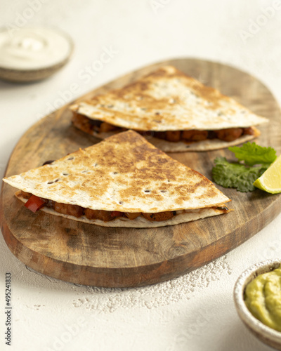 Quesadilla with chicken, guacamole, lime on serving desk
