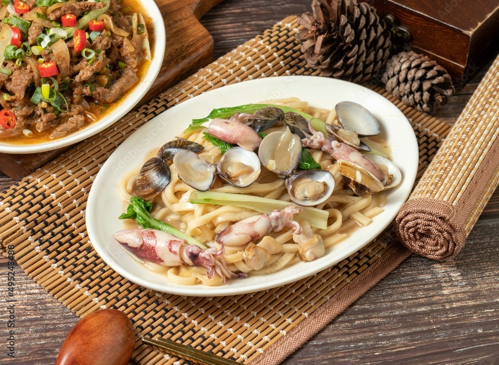 fried noodles with clam rolls in a dish isolated on mat side view on dark wooden table taiwan food fried noodles with clam rolls in a dish isolated on mat side view on dark wooden table taiwan food