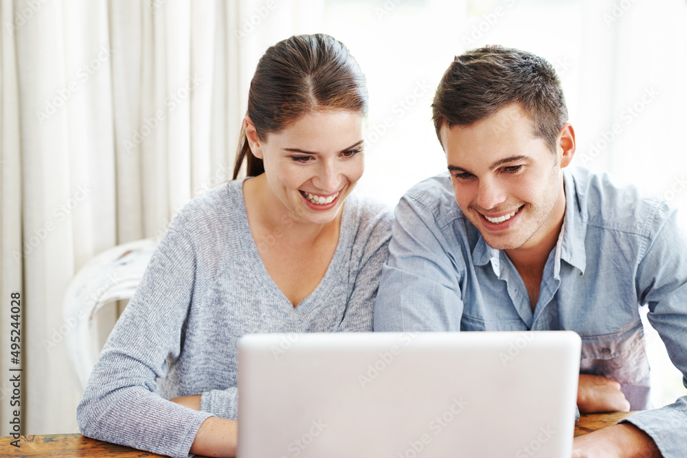 Searching the web together. A young couple using a laptop together at home. Searching the web together. A young couple using a laptop together at home.