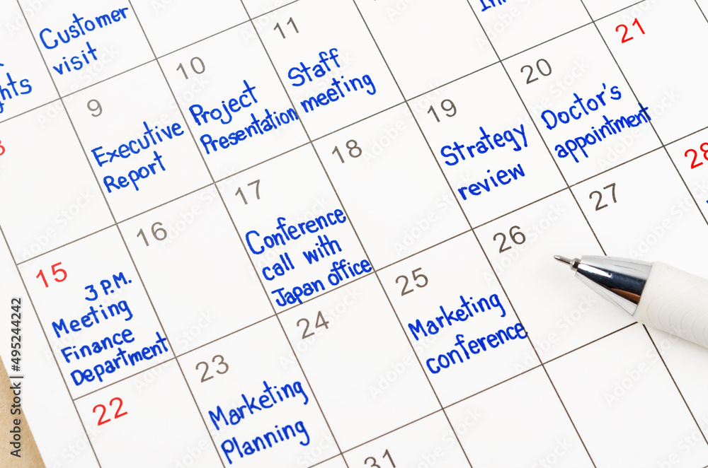 Handwriting scheduling appointments on calendar sheet with pen. Handwriting scheduling appointments on calendar sheet with pen.