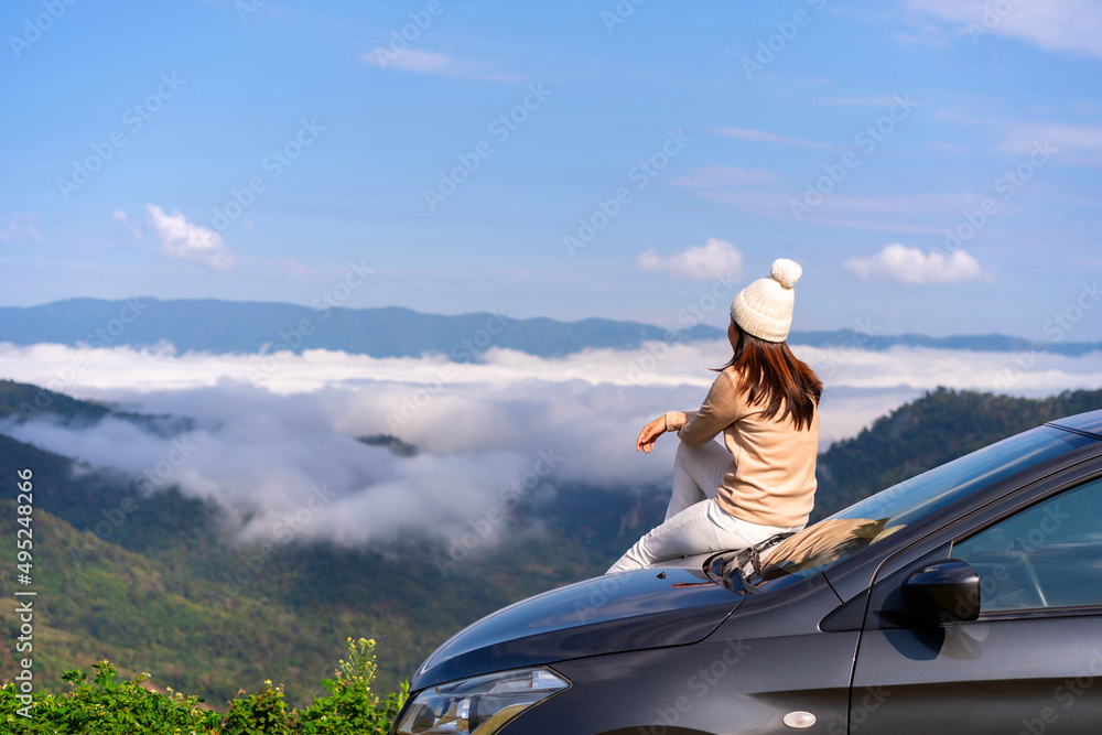 Young woman travelers with car watching a beautiful sea of fog over the mountain while travel driving road trip on vacation