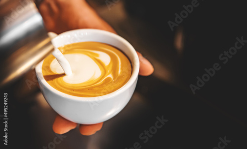 Barista hand making cappuccino Coffee with espresso and milk in cafe photo