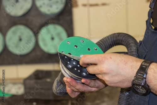 Tableau sur toile A person changes green sandpaper for a sander