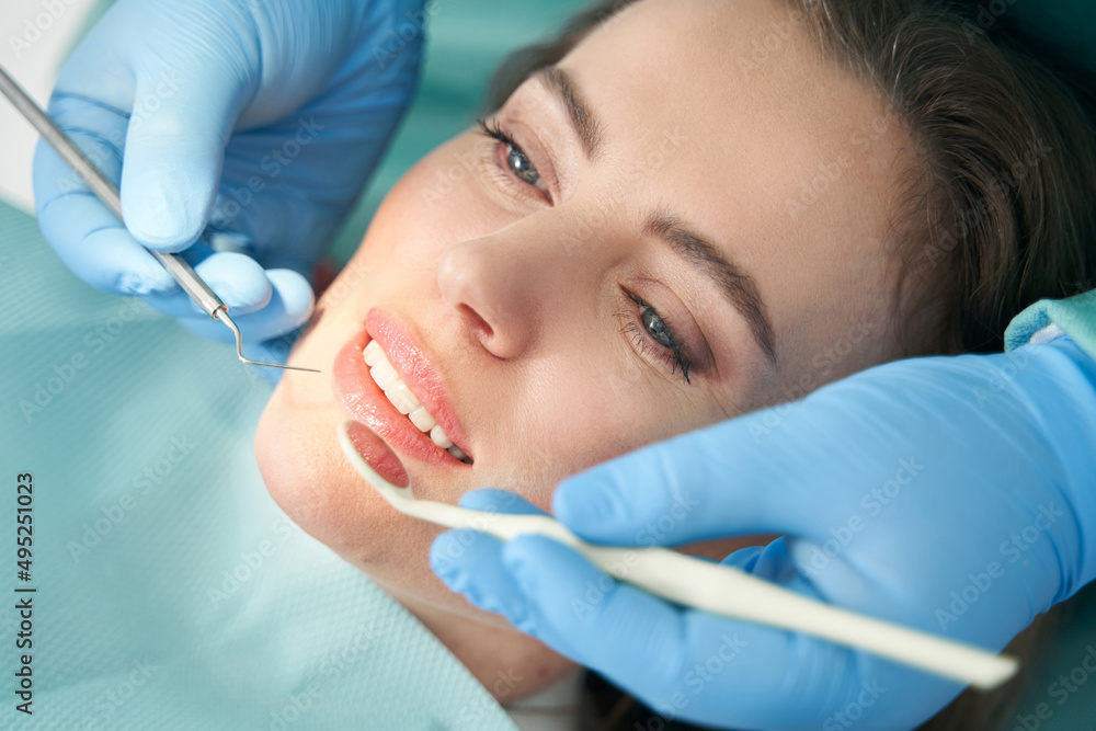 Dentist examining woman teeth in stomatology clinic Dentist examining woman teeth in stomatology clinic