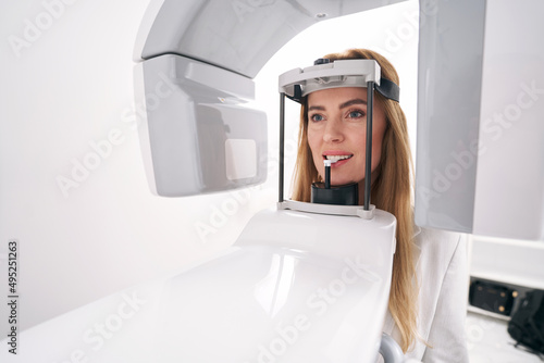 Woman using dental diagnostic equipment in stomatology clinic photo