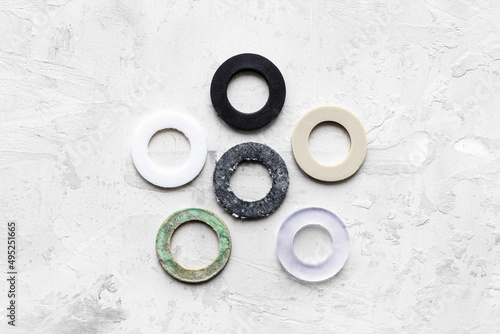 top view of various gaskets for piping water systems on gray concrete background (rubber, vacuum rubber, silicone, ptfe, paronite) photo