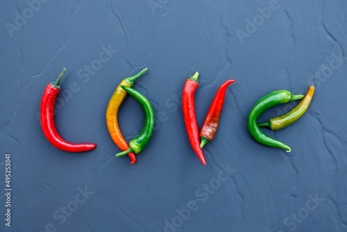 Word Love made of multi colored hot chili peppers on gray background