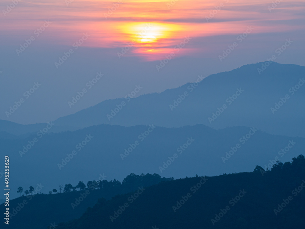 Beautiful nature of sunrise and mountains complex with morning mist atmosphere at Tak, Thailand.
