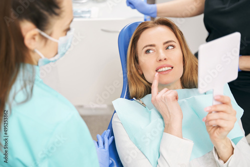 Woman discussing dental treatment with dentist in clinic