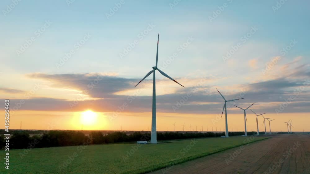 Wind power station. Green energy. A renewable source of powerful electrical energy. Ecology. Sunset. Aerial photography video shooting. Wind turbine. Generator. Wind power station. Green energy. A renewable source of powerful electrical energy. Ecology. Sunset. Aerial photography video shooting. Wind turbine. Generator.