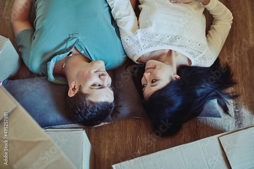 Our happy ever after starts today. High angle shot of a happy young couple lying on the floor. photo