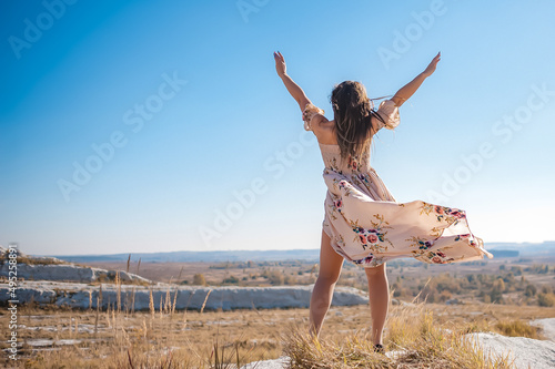 A girl in a summer dress enjoys the journey