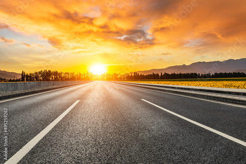 Empty asphalt road and colorful sky clouds at sunrise © ABCDstock