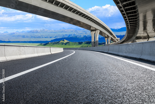 Empty asphalt road and bridge with mountains background