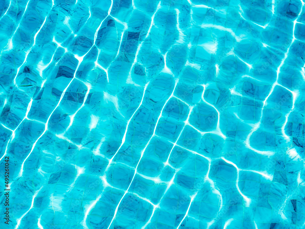 Clean and clear blue water surface with movement wave shining with the light on the swimming pool background. Empty blank space for summer background, vacation time, holiday concept.