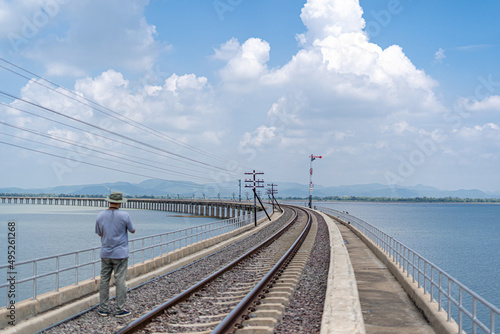 Lopburi Thailand-March 25,2022 :A man take a picture the railway and  blue sky at Khok Salung Railway landmark of Thailand.