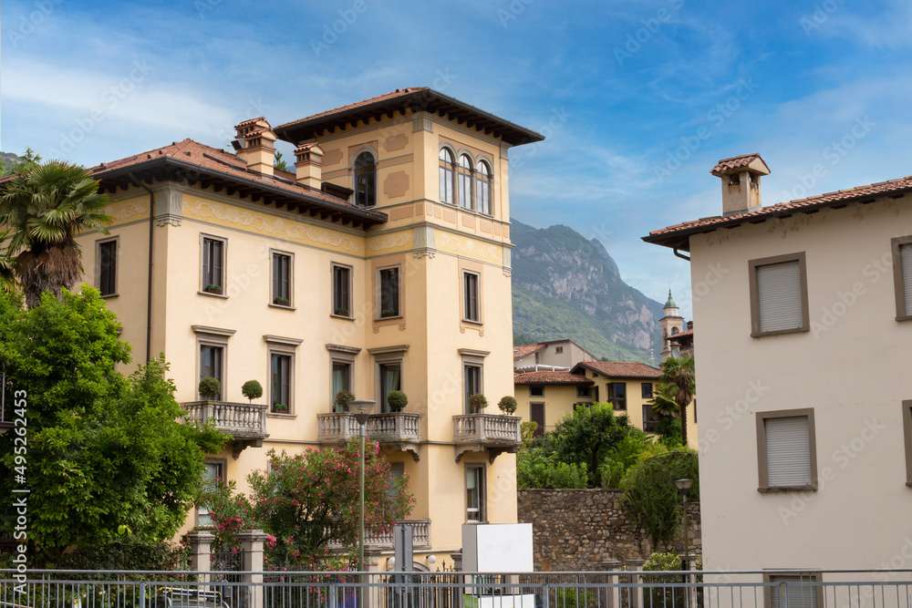 Beautiful panorama of the old Italian town of Lovere with beautiful houses with tiled roofs against the backdrop of mountains on a sunny day.