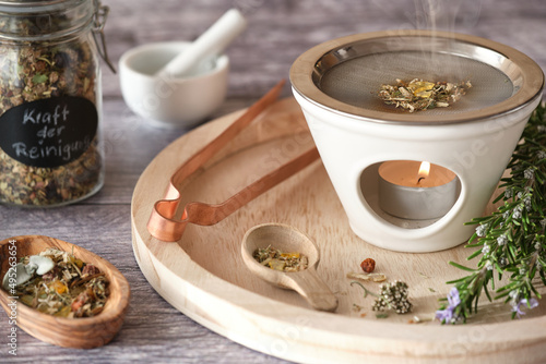 Burning various types of incense in an incense burner with tea light: frankincense, resins, sandalwood and herbs like rosemary and white sage - spring still life