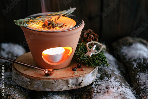 Burning various types of incense in an incense burner with tea light: frankincense, resins, sandalwood and herbs like rosemary and white sage - winter still life