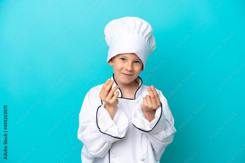 Little chef boy isolated on blue background making money gesture Little chef boy isolated on blue background making money gesture